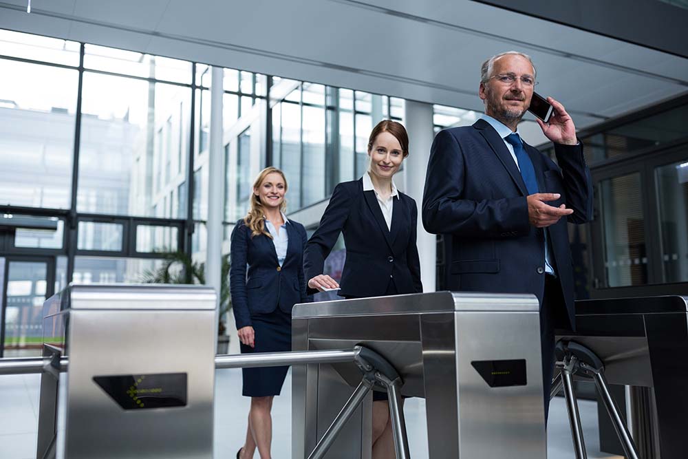 Businesspeople scanning their cards at turnstile gate access control turnstile for business and public property security, gta access control,